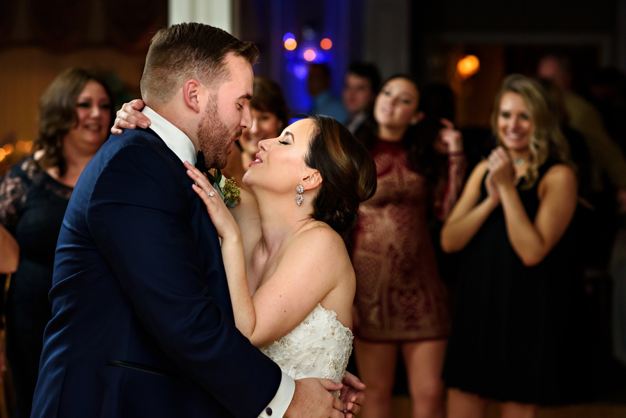 A bride kissing her groom on the dancefloor at their reception.